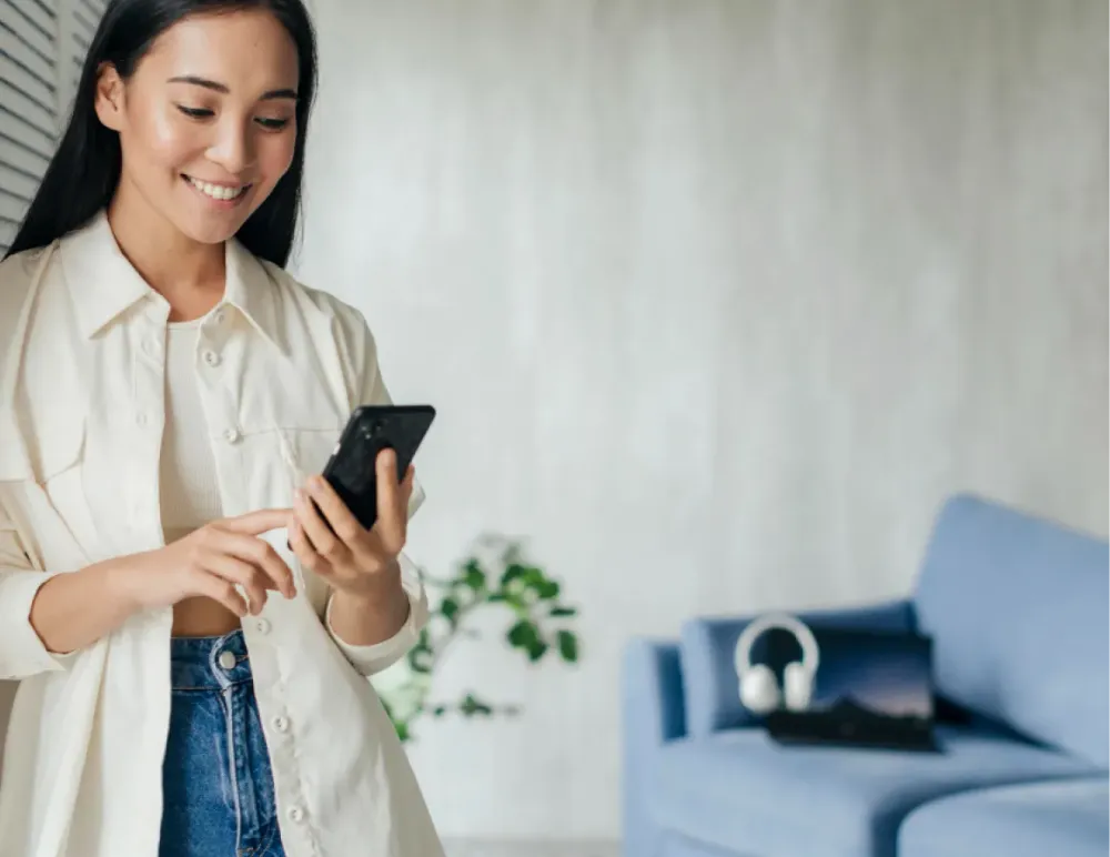 Frau schaut lächelnd auf ihr Smartphone
